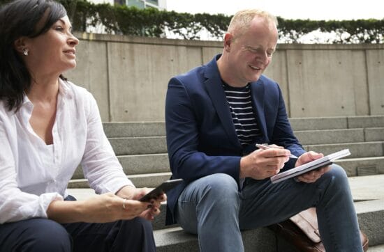 woman and man having a discussion while sitting on steps